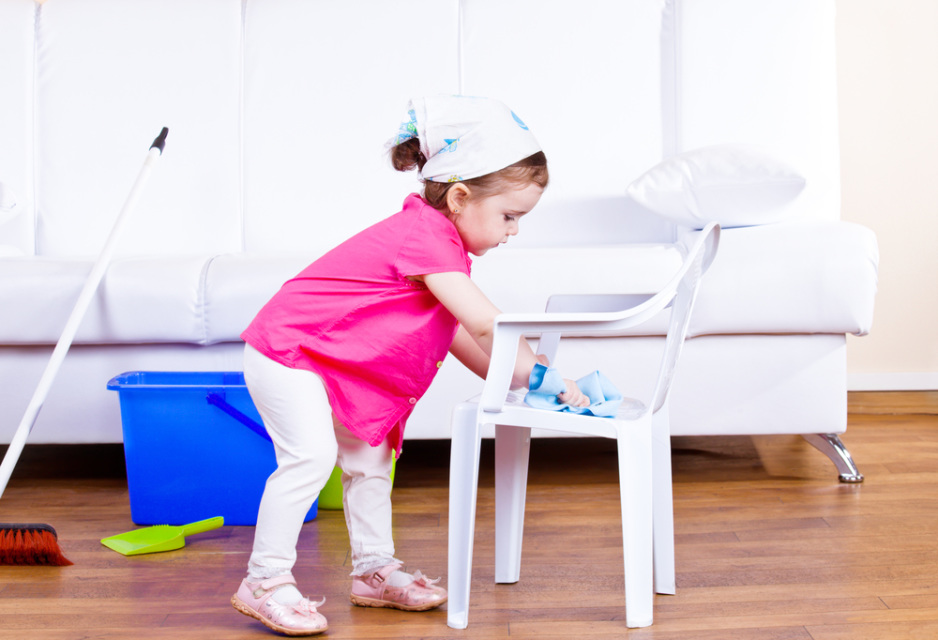 Little girl wiping  dust off a kid chair